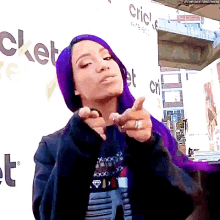 a woman with purple hair is standing in front of a wall that says cricket