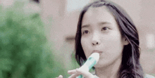 a young woman is playing a flute in her mouth .