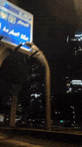a billboard with arabic writing on it is above a bridge