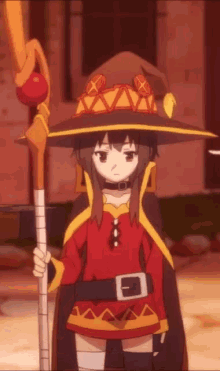 a girl in a witch costume is holding a staff