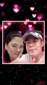 a man and a woman are posing for a picture with pink hearts surrounding them
