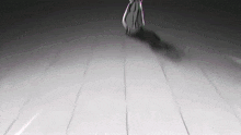 a black and white photo of a person walking on a white floor .