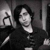 a black and white photo of a young man in front of a piano