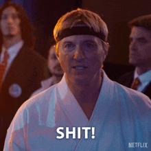 a man in a karate uniform says shit in front of a group of men