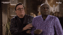 two men are standing next to each other with a hulu logo in the background