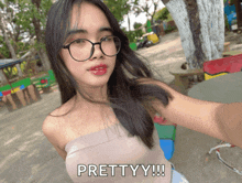 a woman taking a selfie with the words prettyy written below her