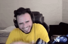a man wearing headphones is sitting in a chair and smiling .