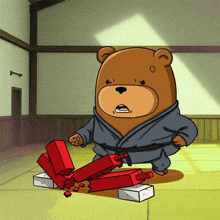 a cartoon bear in a karate uniform is standing next to a pile of red blocks