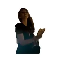 a woman in a black shirt applauds with her eyes closed