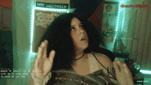 a happy halloween sign hangs above a woman