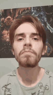 a man with red hair and a beard is standing in front of a poster that says diablo ii