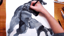 a person is drawing a black panther with a marker