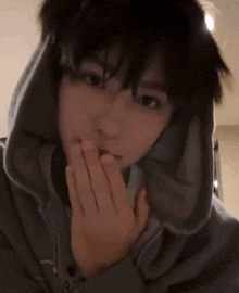 a close up of a person wearing a hoodie covering their mouth