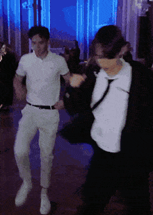 two men are dancing together in a dark room with blue lights