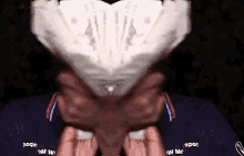 a person is holding a piece of paper in front of their face