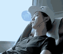 a man wearing a hat with the letter t on it is sleeping in a chair