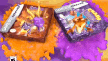 two video games are sitting on top of a table covered in purple and orange paint .