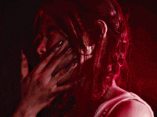 a woman in a white tank top is surrounded by red and blue smoke