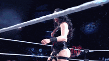 a woman is standing in a wrestling ring with a w logo in the background