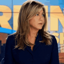 a woman in a blue suit stands in front of a sign that says run show