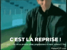 a man in a black jacket is standing in front of a screen that says c ' est la reprise !