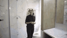 a woman standing in a bathroom with the words made in animatica on the bottom right