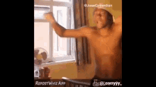 a shirtless man is standing in front of a window with his arms outstretched