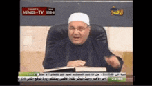 a man is sitting in front of a screen that says memri-tv