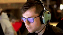 a man wearing glasses and headphones with the letter e on the bottom