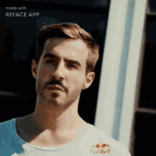 a man with a beard is wearing a white shirt that says red bull
