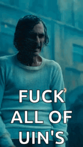a man in a white sweater with the words " fuck all of uin 's " on it