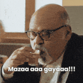 a man with glasses and a beard drinking from a glass with the caption mazaa aaa gayaaa !!