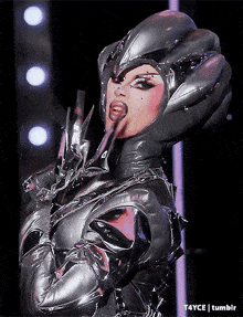 a woman in a futuristic costume is sticking out her tongue ..