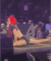 a woman is doing a split on a stage in front of a crowd .
