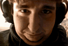 a close up of a man wearing headphones looking at the camera