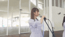 a woman is singing into a microphone in a room .