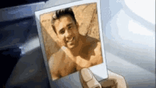 a person is holding a picture of a man without a shirt .