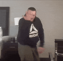 a man wearing a reebok sweatshirt is dancing