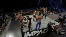 a group of wrestlers are in a ring with a sign that says impact