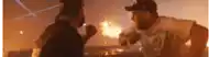 two men are standing next to each other in front of a fire .