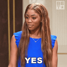 a woman in a blue dress has the word yes written on her face