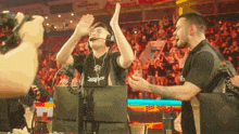 a man wearing headphones and a shirt that says ninjas is giving another man a high five