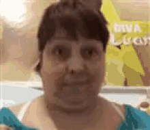 a woman wearing glasses and a blue shirt is making a funny face .