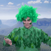 a man with a green wig and green leaves on his body