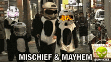 a group of people walking down a street with the words mischief and mayhem written on the bottom