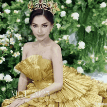 a woman in a gold dress with a crown on her head with mgt 2025 written on the bottom