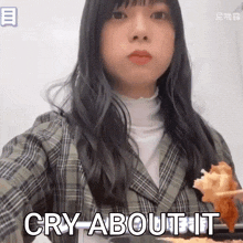 a woman in a plaid jacket is holding a piece of food and says cry about it