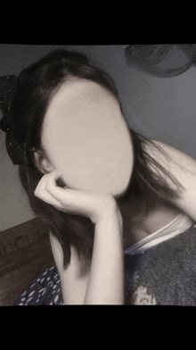 a woman without a face is resting her head on her arm