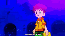 a boy in a yellow shirt is standing next to a red robot