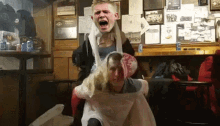 a man is sitting on another man 's shoulders with a screaming face on his face